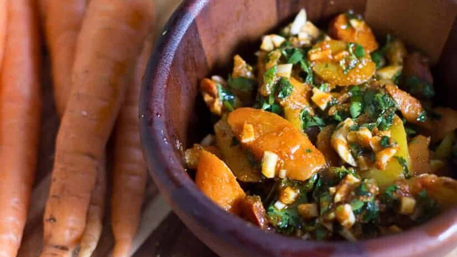 A bowl of carrots and parsley in a wooden bowl.