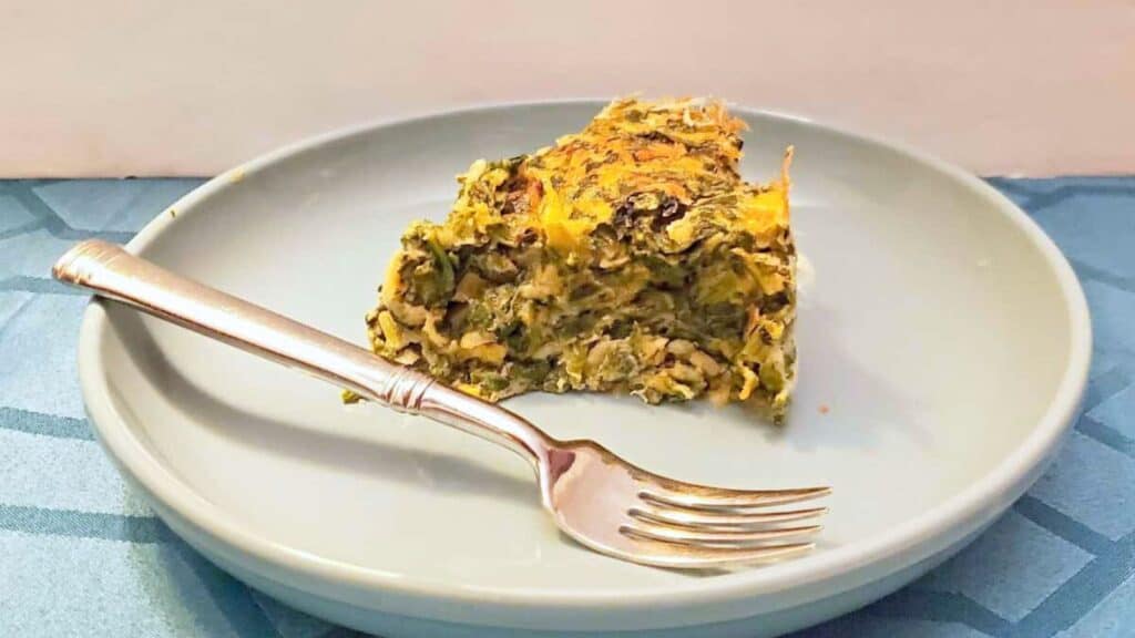 Image shows A piece of spinach souffle on a plate with a fork.