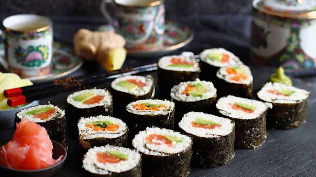 Japanese sushi rolls on a plate with chopsticks.