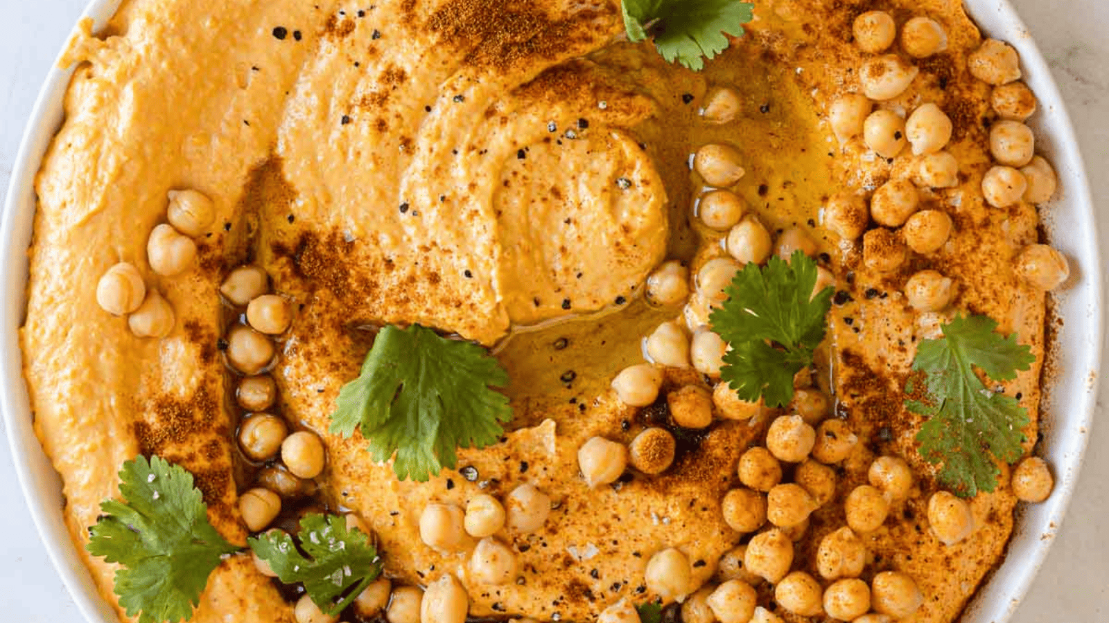 Holiday appetizers featuring hummus with chickpeas and parsley.