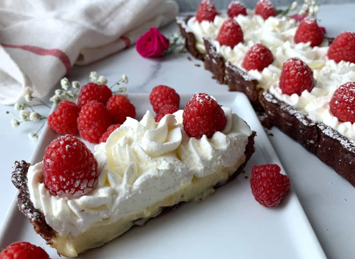 Raspberry vanilla bean tart on a white plate.