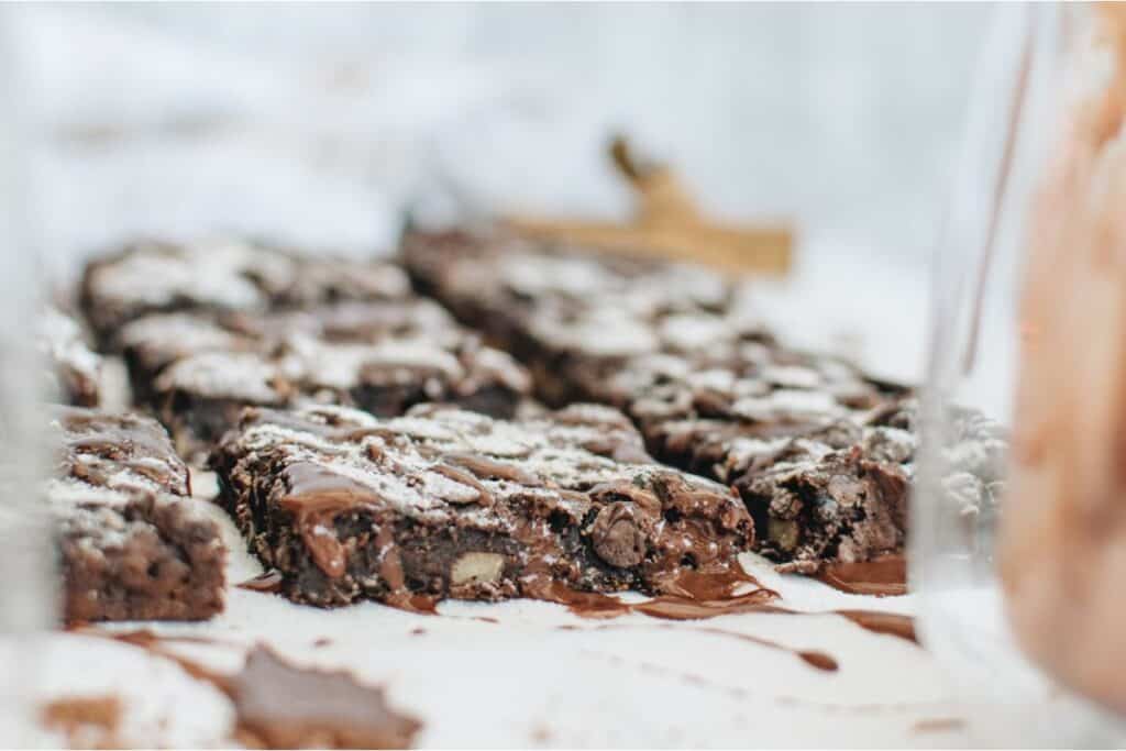 A plate of chocolate brownies with sprinkles on top.