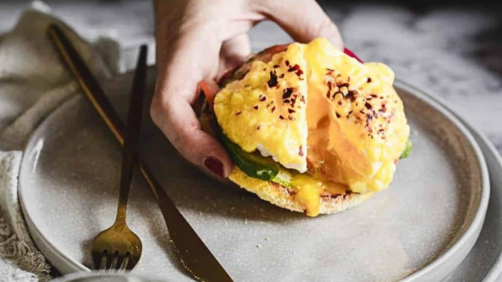 A person holding a vegetarian eggs benedict.