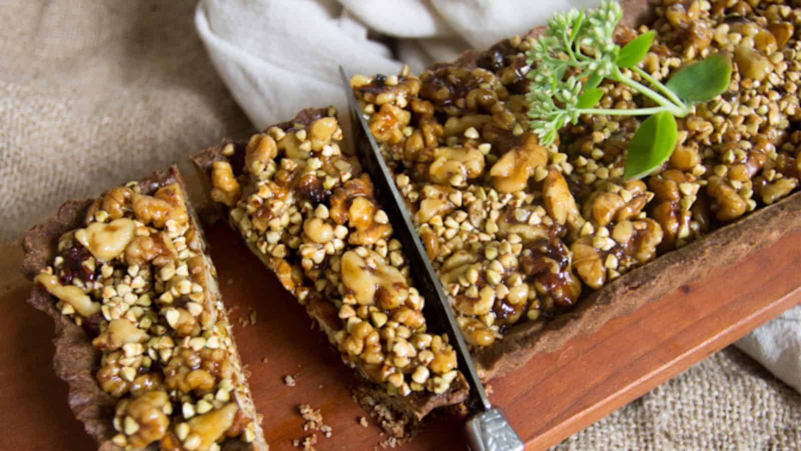 A walnut tart on a wooden cutting board with sprigs of thyme.