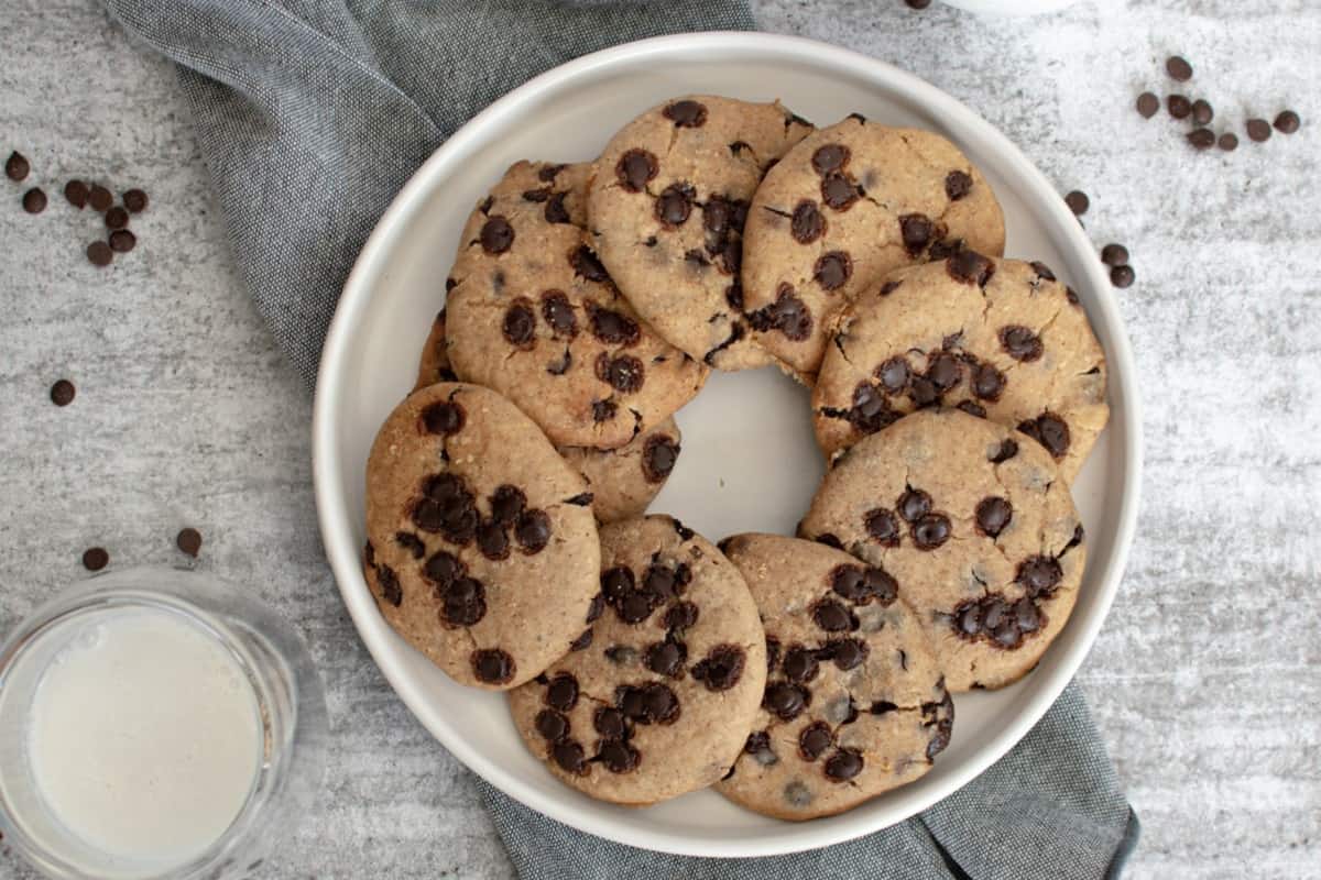 Chocolate chip cookies on a plate with milk.