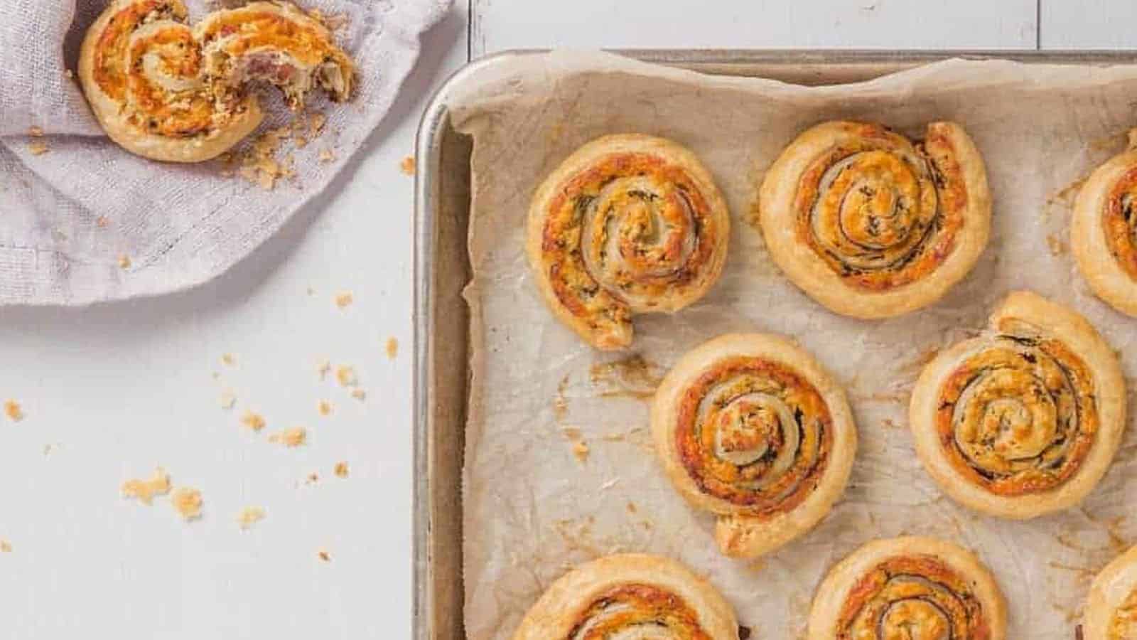 Cheddar cheese pinhwheel appetizers on a baking sheet.