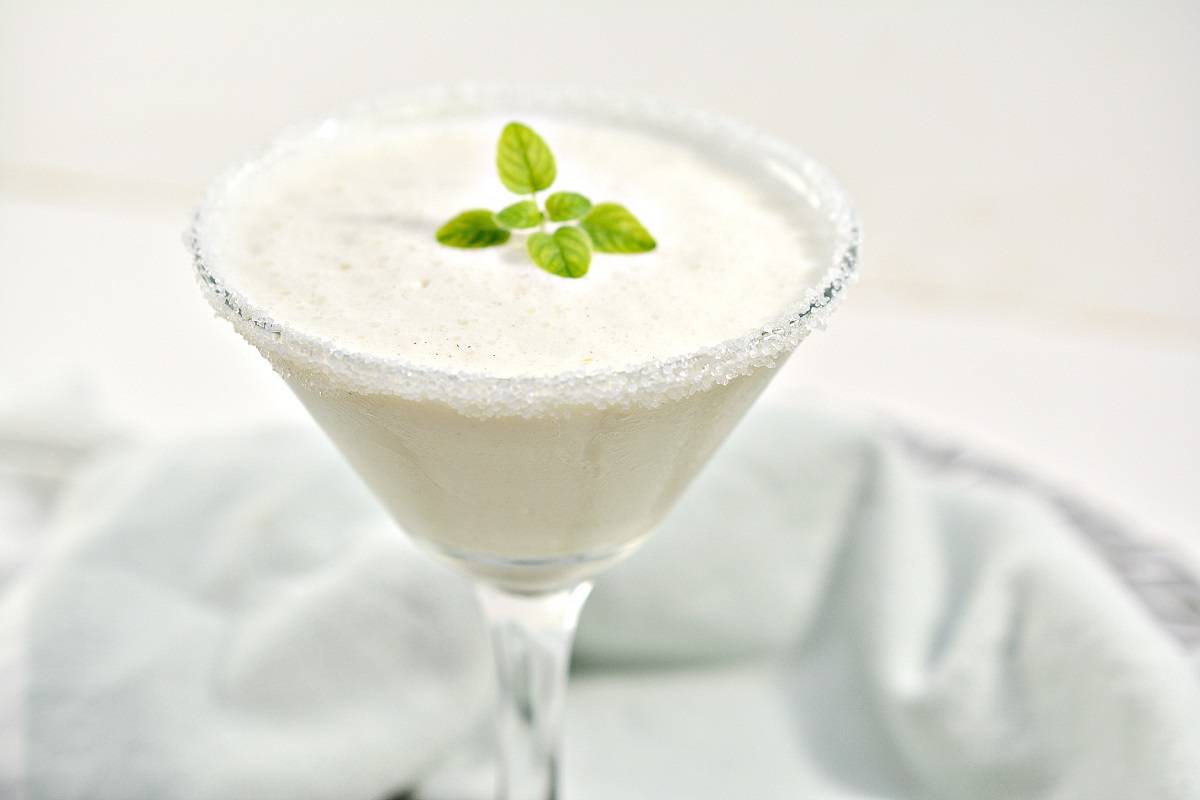 A martini with a salt rim and mint leaves.