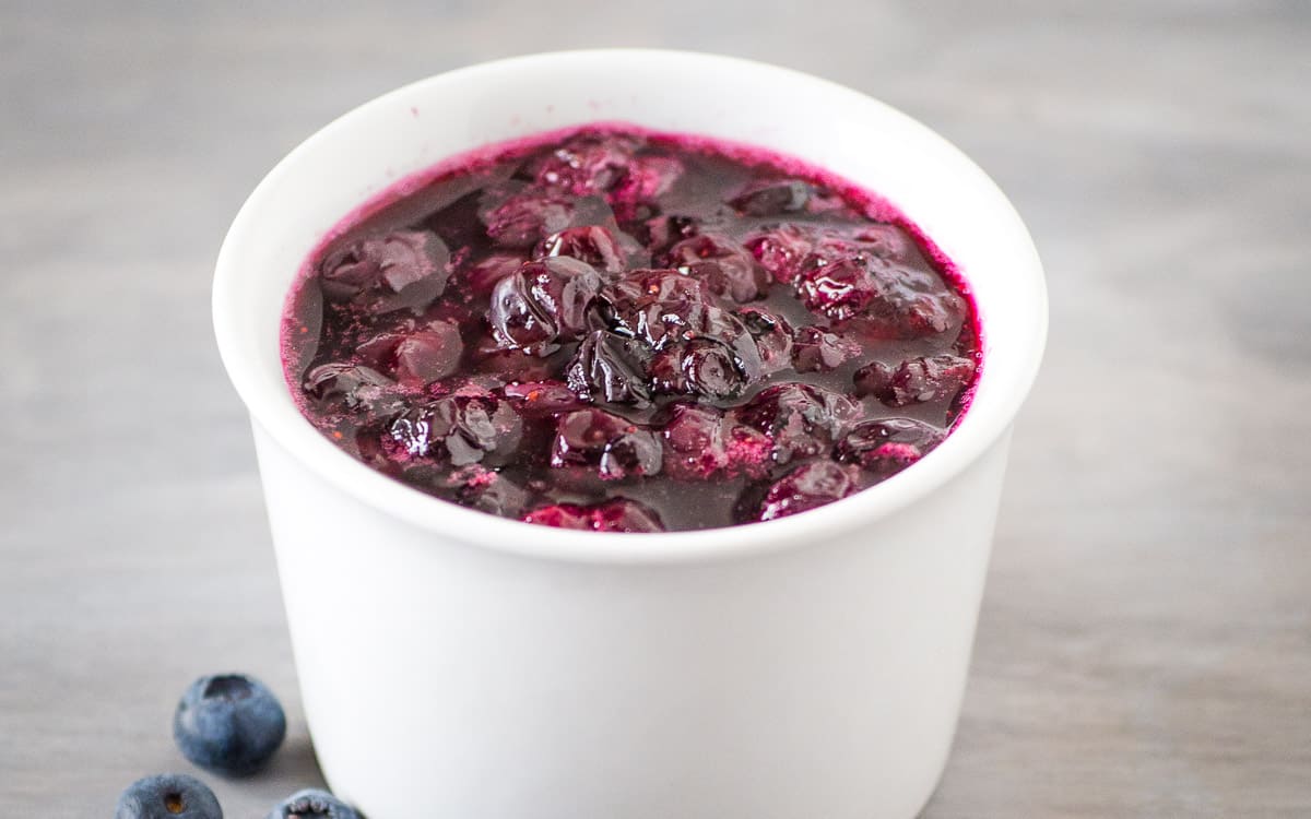 Homemade blueberry sauce in a white bowl.