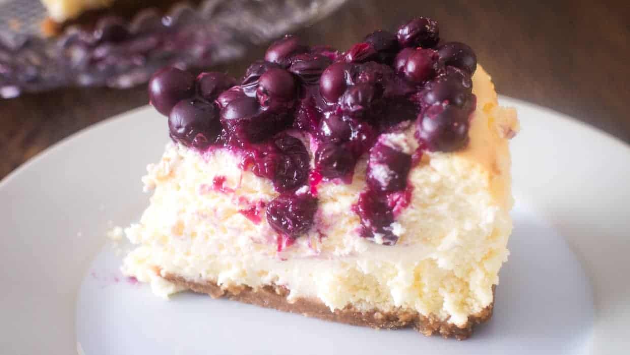 Slice of blueberry cheesecake on a plate.