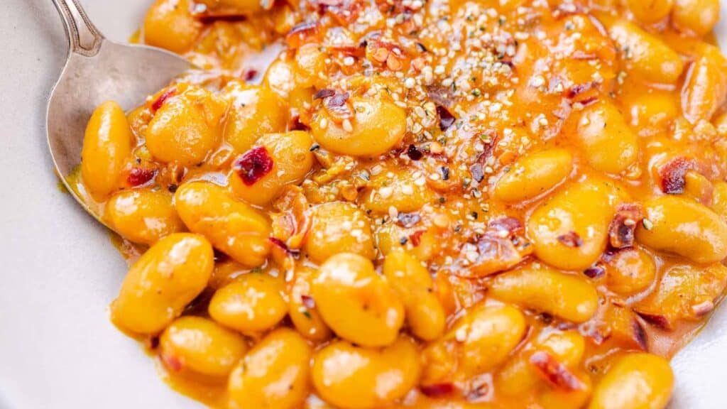 A bowl of baked beans with a spoon.