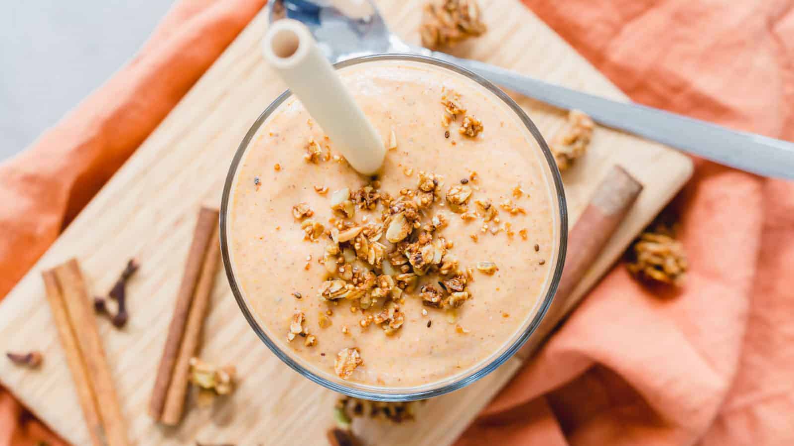 A butternut squash smoothie with cinnamon and nutmeg on a wooden cutting board.