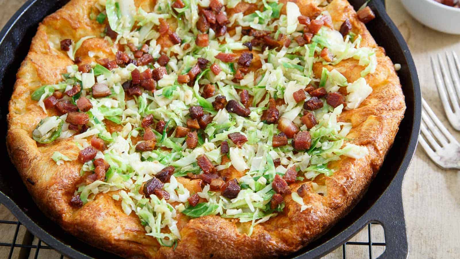 Cheddar bacon Dutch baby pancake in a cast iron skillet.