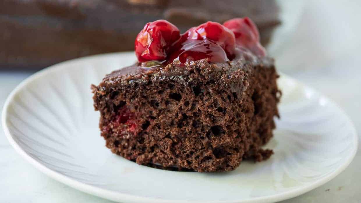 Slice of chocolate cherry cake topped with cherry pie filling.