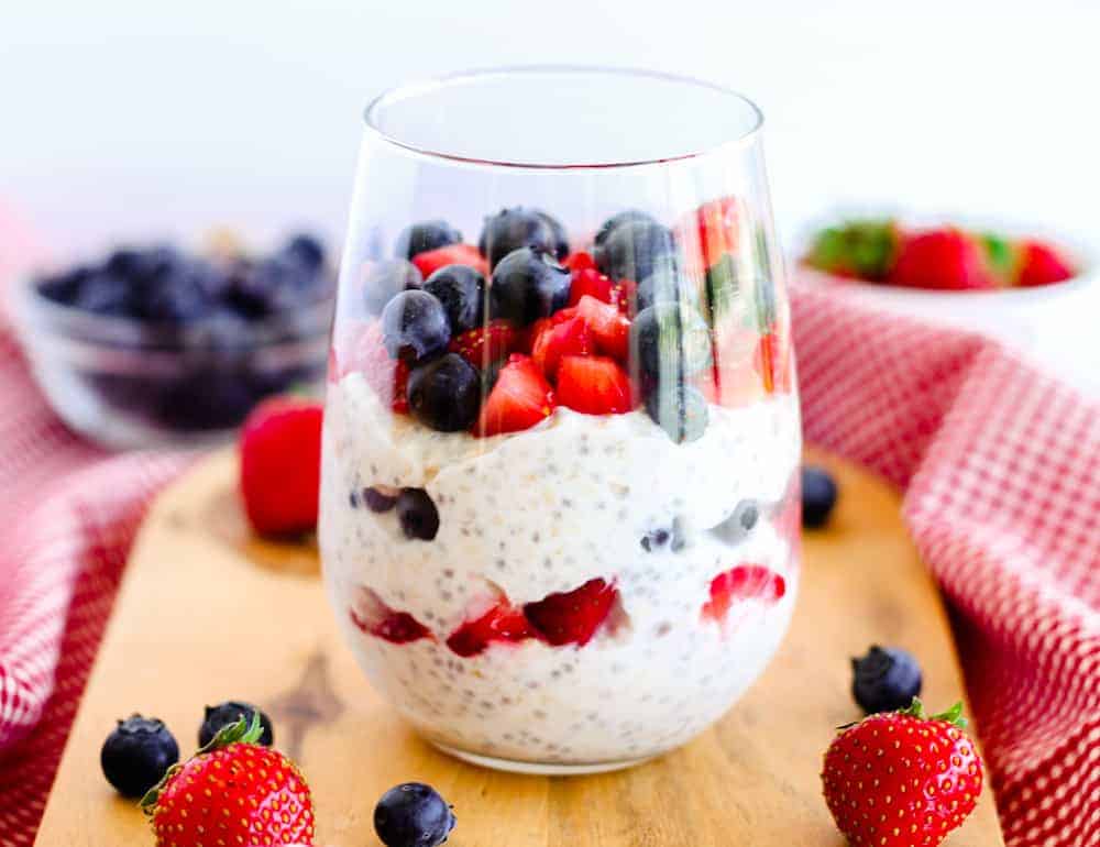 A glass of chia pudding with berries and blueberries.