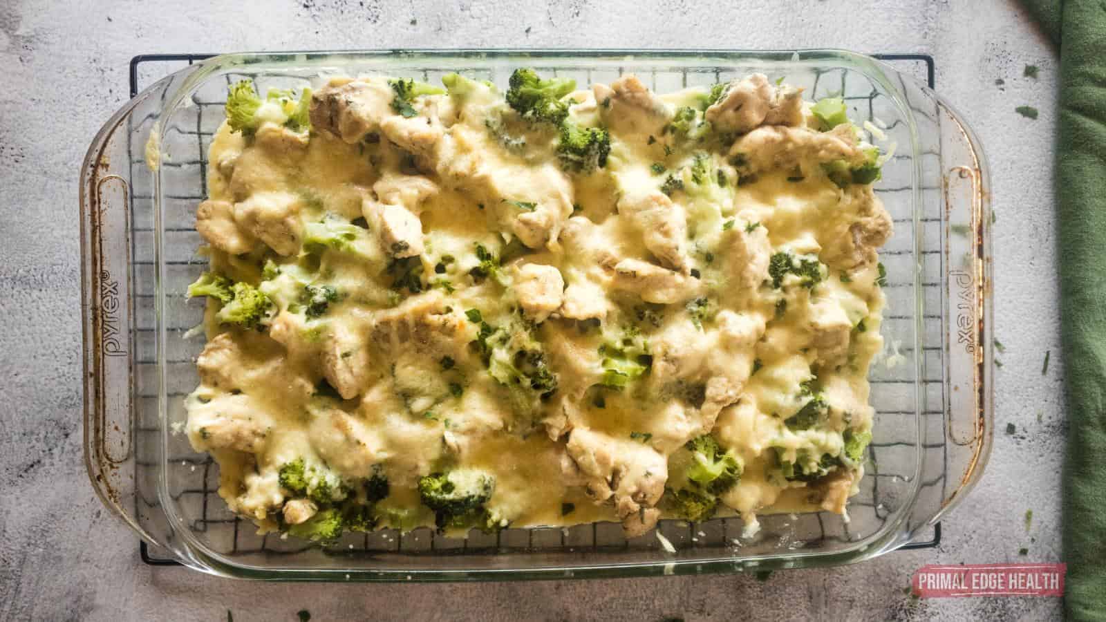 Chicken alfredo broccoli bake cooking in dish on rack.