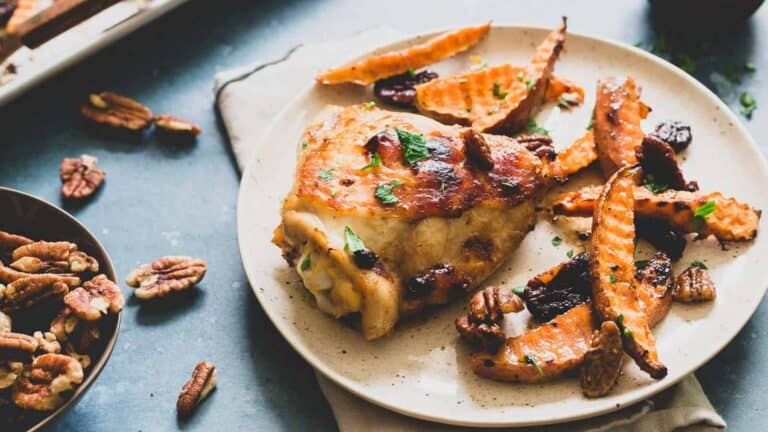 Chicken and sweet potato fries on a plate with toasted pecans.