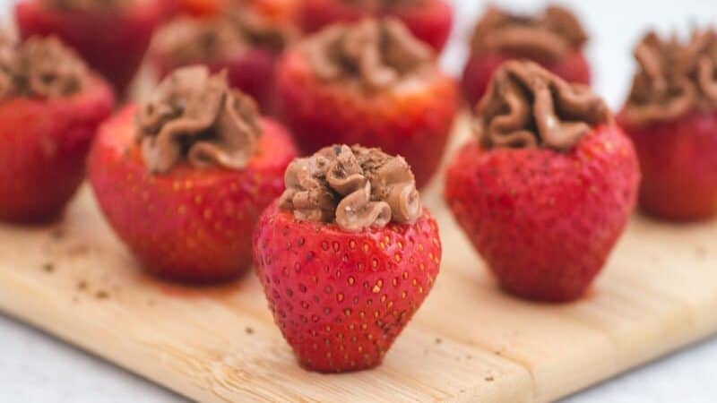 Chocolate covered strawberries on a cutting board.