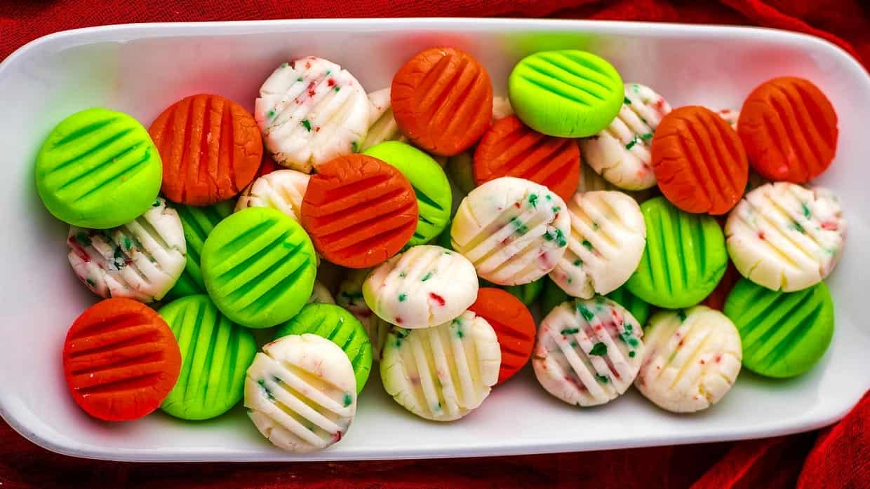 A white plate with green, orange, and red mints.