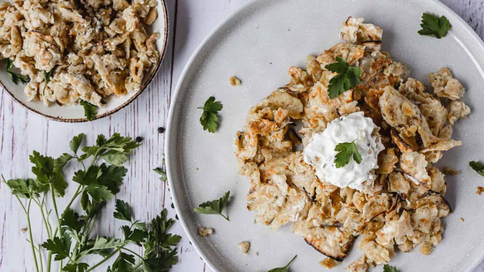 A plate with a plate of fried chicken with sour cream and parsley.