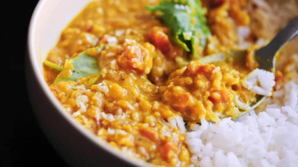 A bowl of rice and curry with a spoon, served in a five-star presentation.