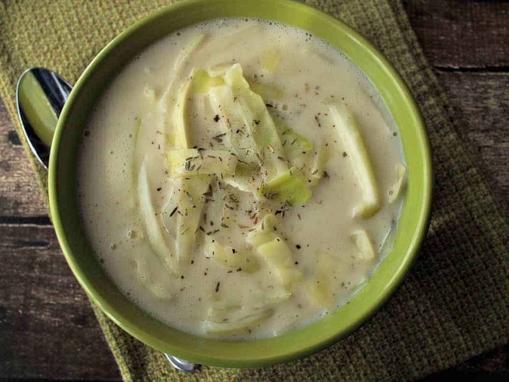 Colcannon Soup in a green bowl with a spoon.