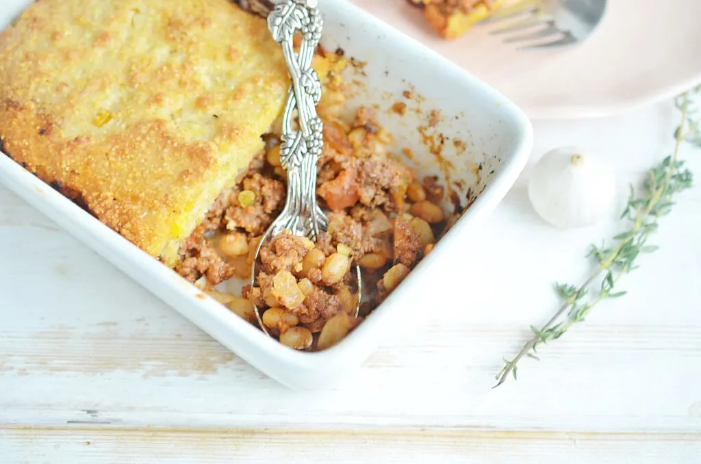 A casserole dish with a large silver spoon.