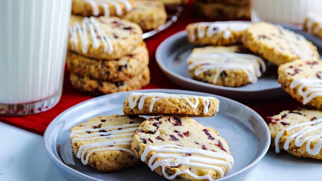 Cranberry cookies with icing and milk on a plate.