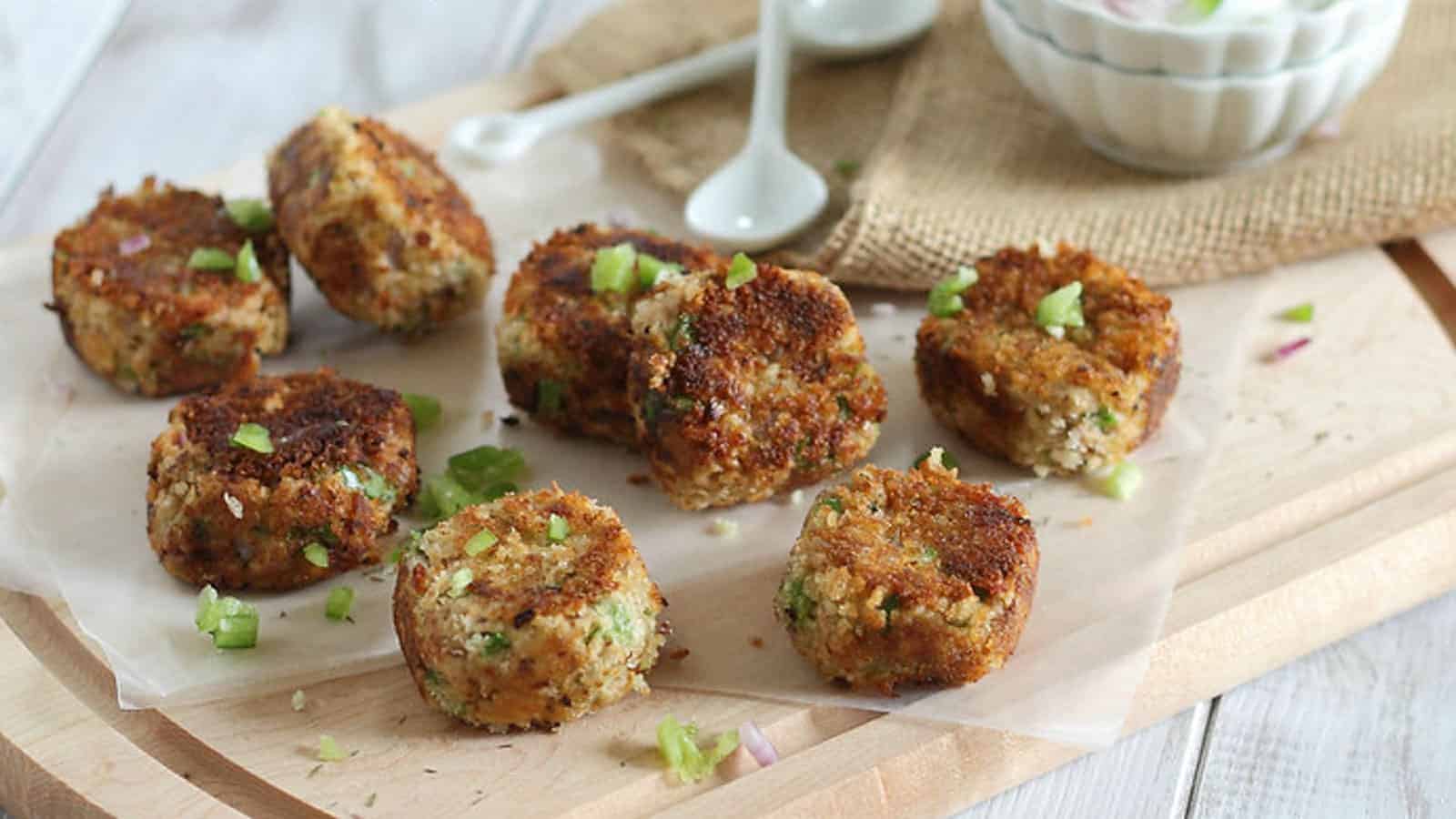 Crispy salmon bites made with canned salmon on a cutting board with dipping sauce.