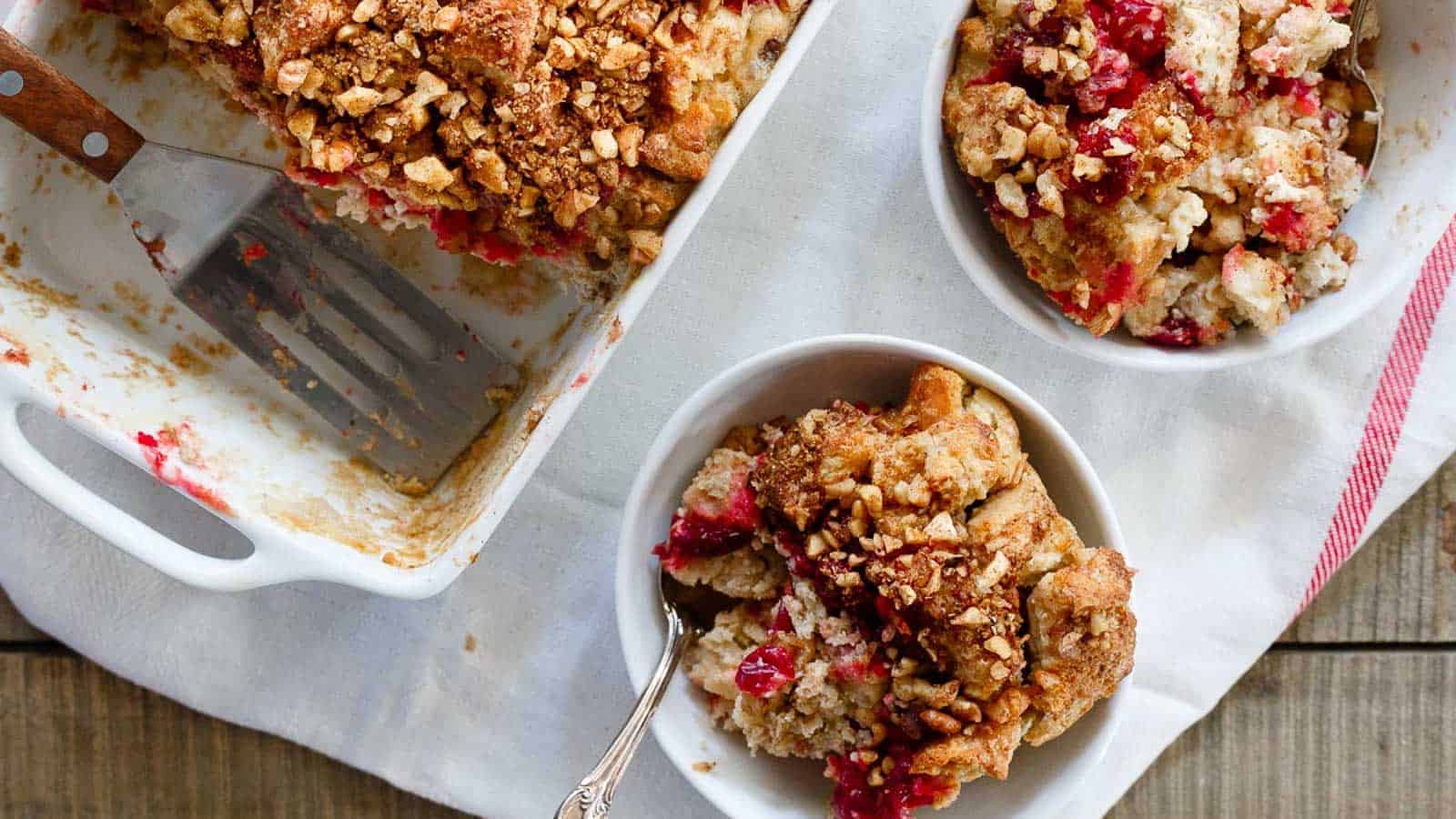 English muffin casserole in small bowls with baking dish in the background.