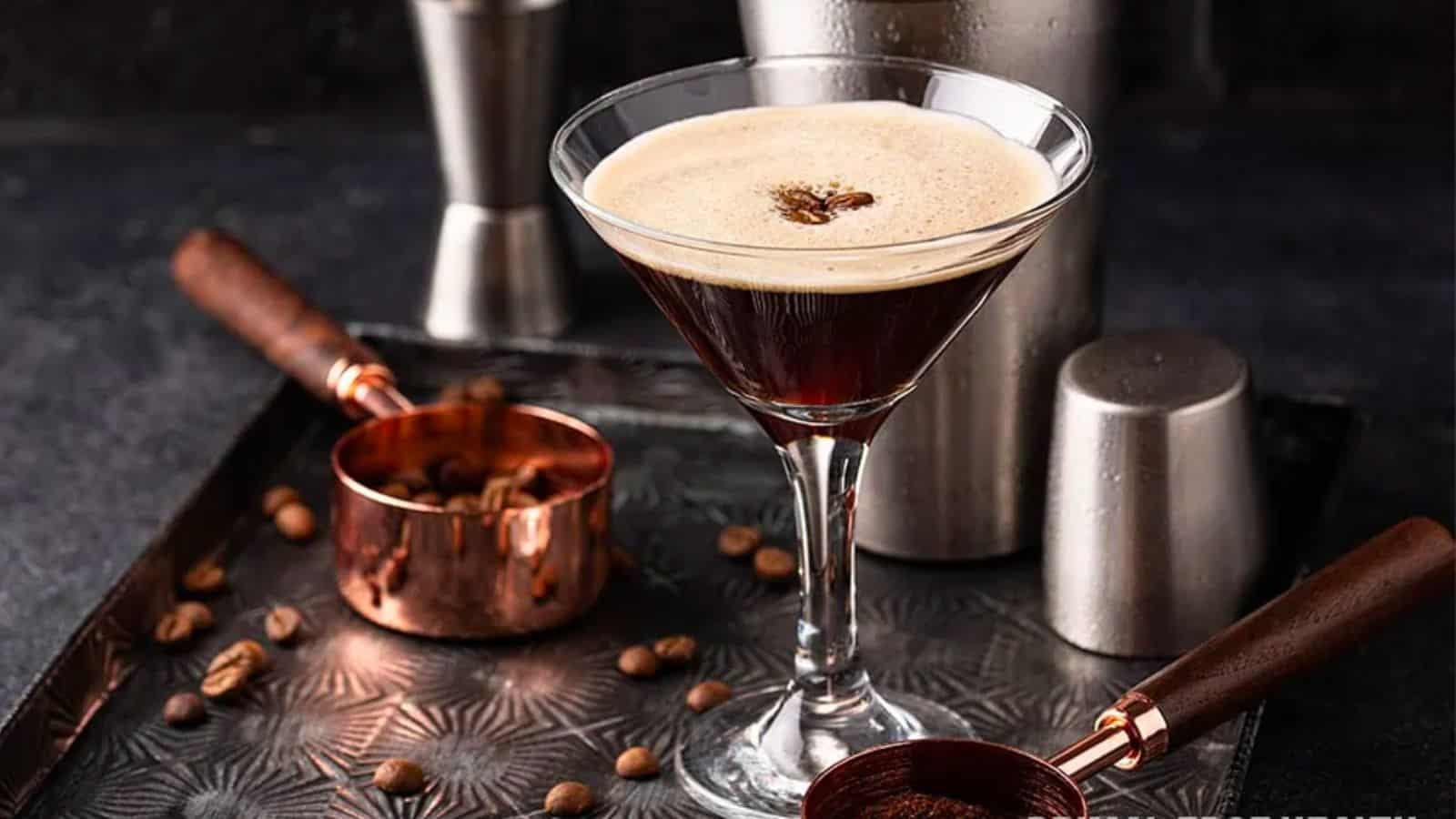 keto espresso martini in martini glass with shaker and bar items in background.