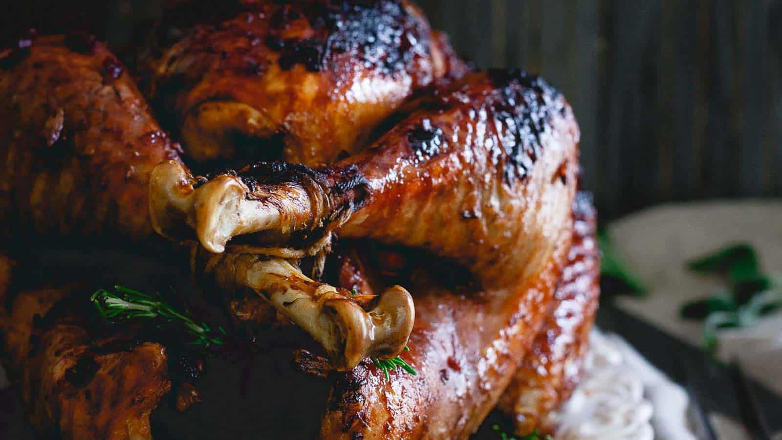 A roasted turkey is sitting on top of rice.