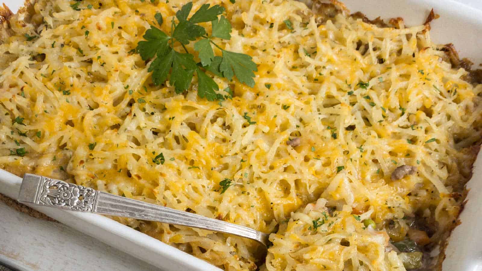 Hashbrown and hamburger casserole in white pan.