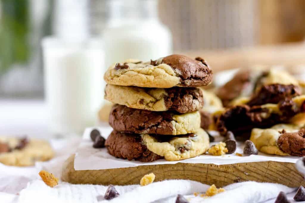 A stack of chocolate chip cookies on a cutting board.