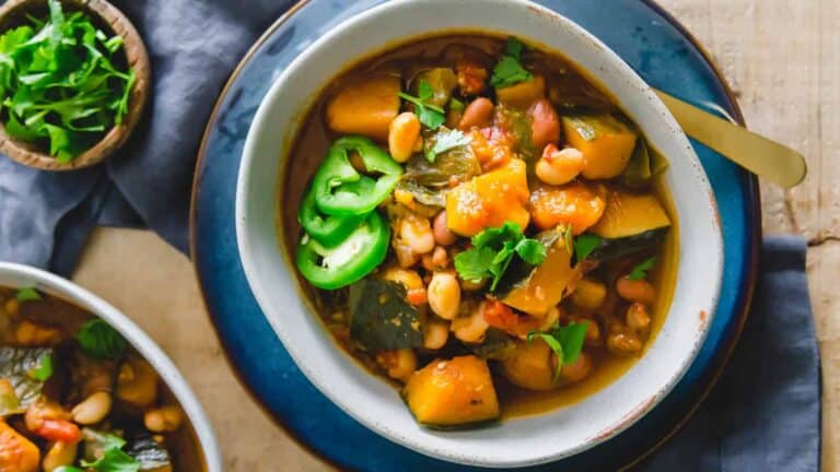 Two bowls of bean and squash stew on a table.