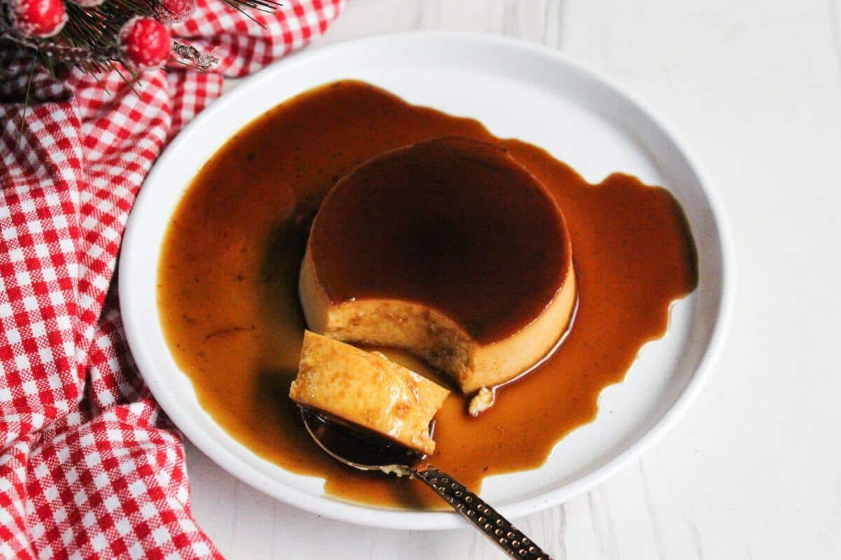 Leche flan caramel creme brulee on a plate with a spoon.