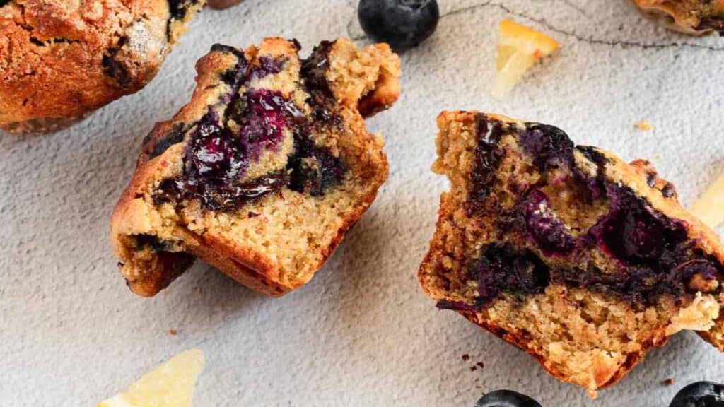 Blueberry muffins with lemon slices on a grey background, perfect for fruit lovers and dessert enthusiasts.