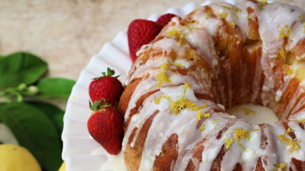 A lemon bundt cake with strawberries and icing.