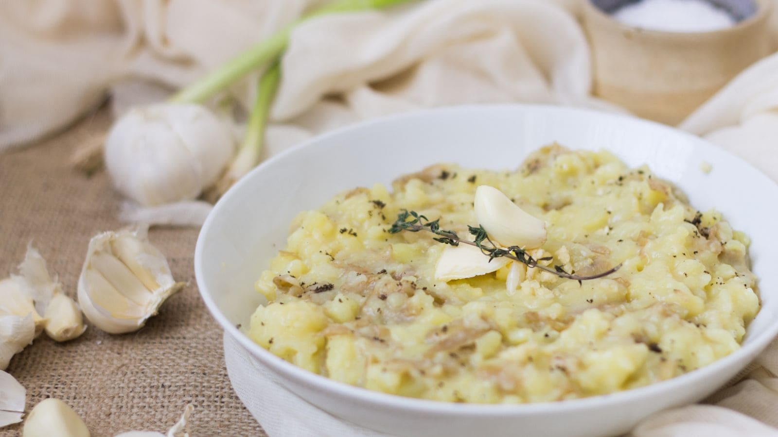 A bowl of mashed potatoes with garlic and thyme.