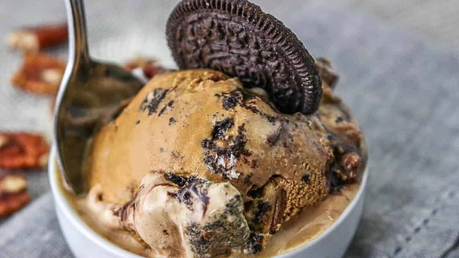 Low angle shot of a bowl of mississippi mud ice cream with an oreo cookie and a spoon stuck in it.