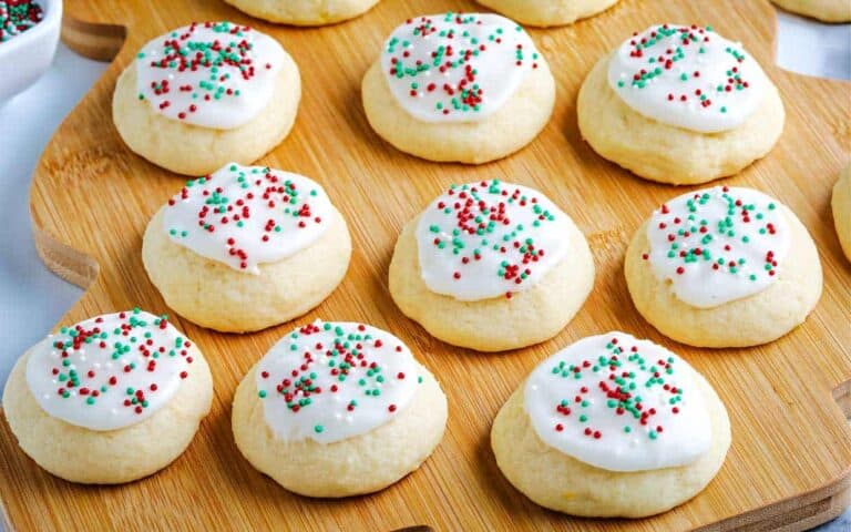 Christmas cookies on a cutting board with sprinkles.