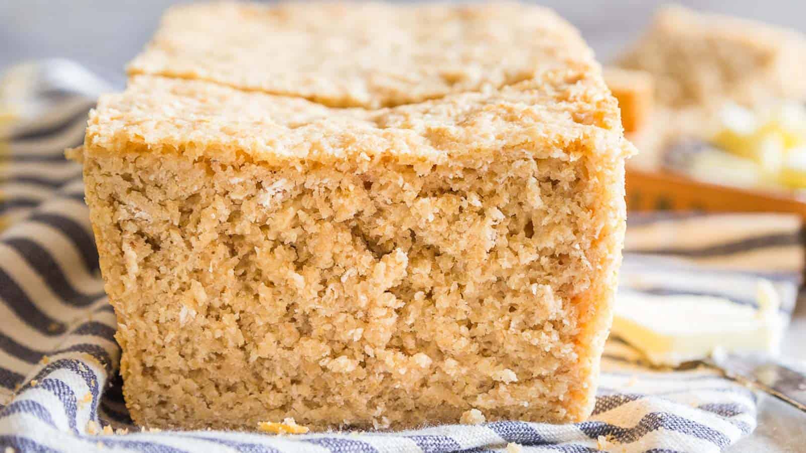 A loaf of sliced oat bread sitting on a towel.