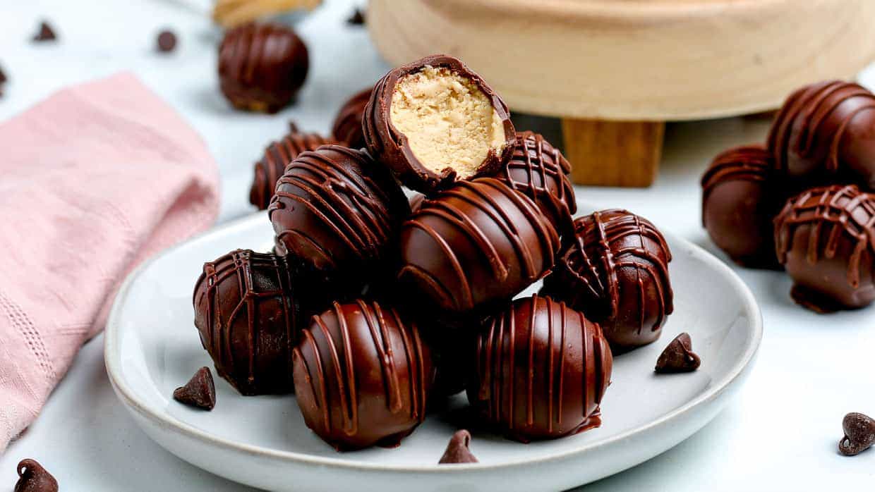 Chocolate coated peanut butter balls stacked in a pyramid.