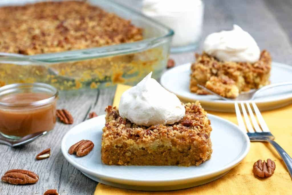 Pumpkin Dump Cake on a plate with whipped cream.