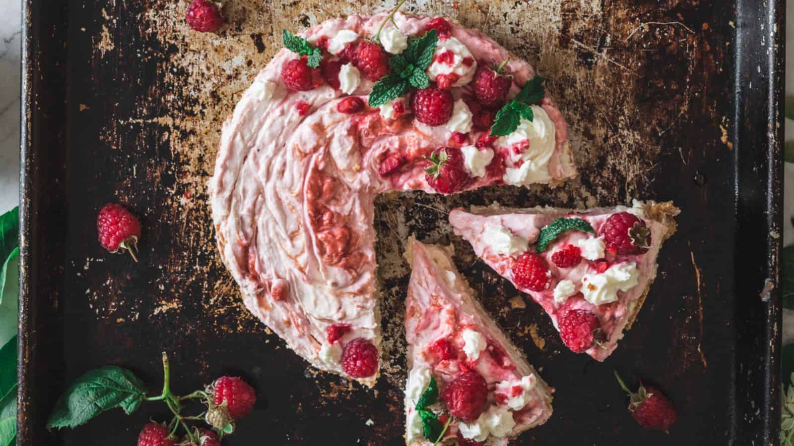 A slice of raspberry cheesecake, a delectable fruit dessert, on a baking sheet.