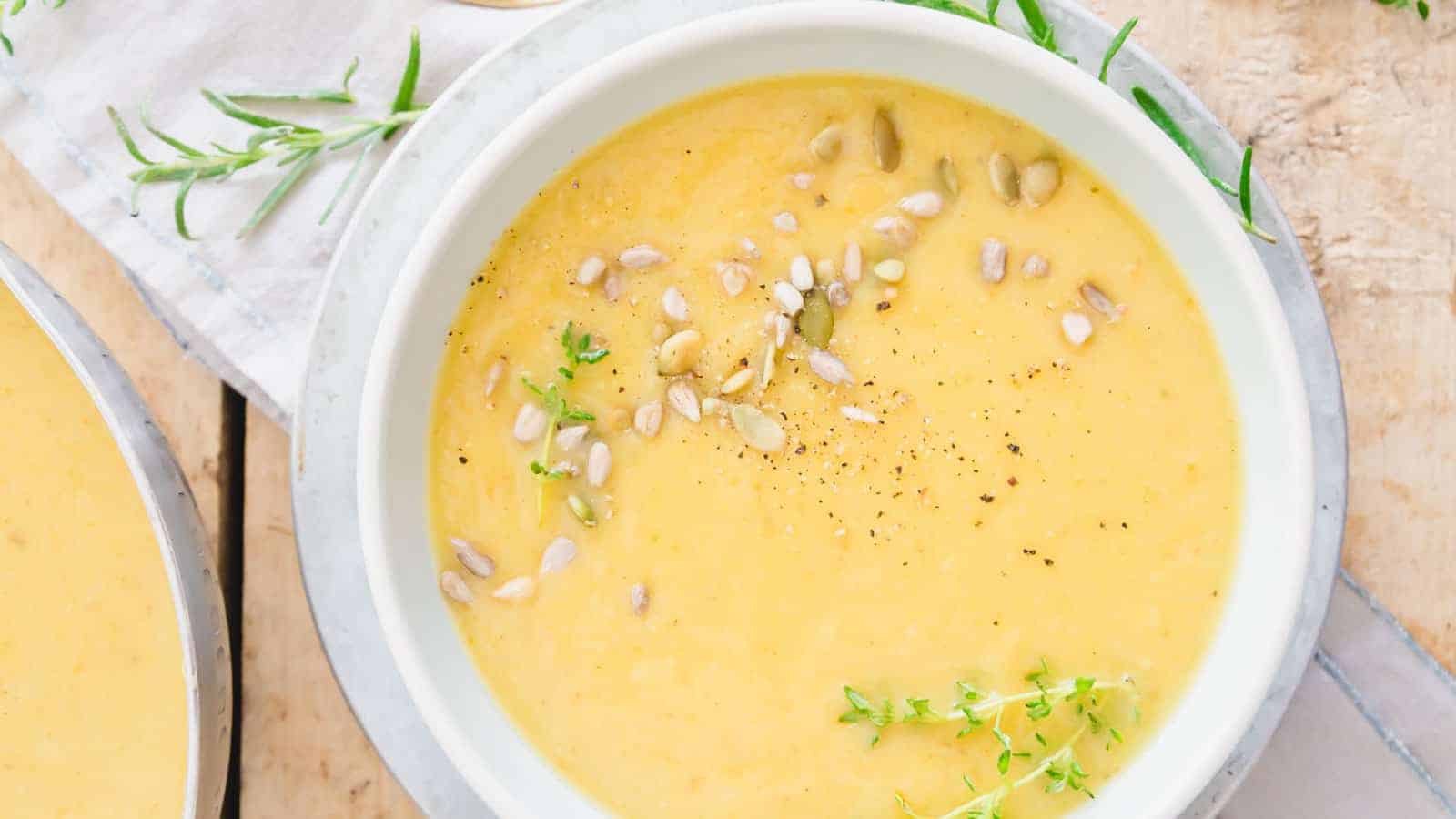 A bowl of creamy root vegetable soup with sprigs of thyme.