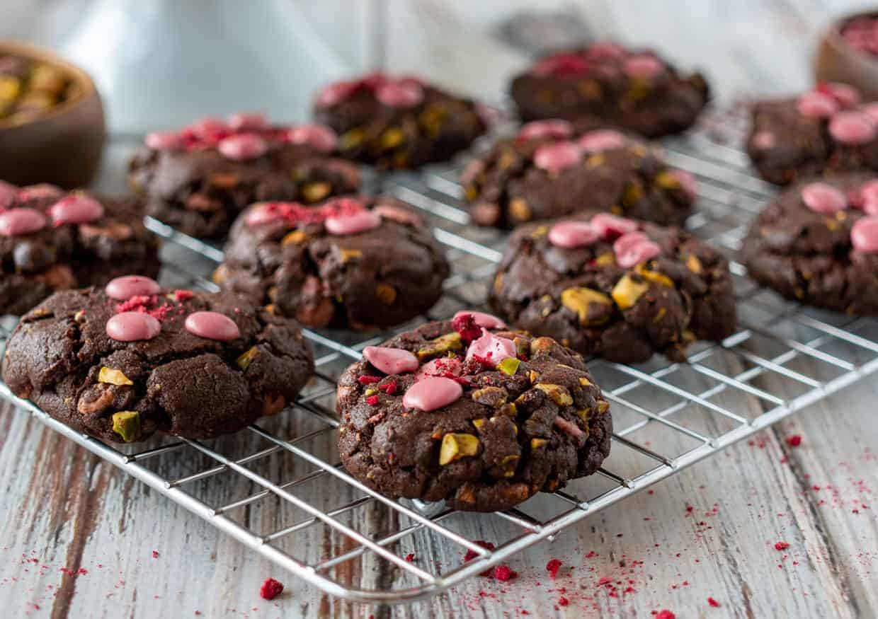 Ruby chocolate chip cookies on a cooling rack.