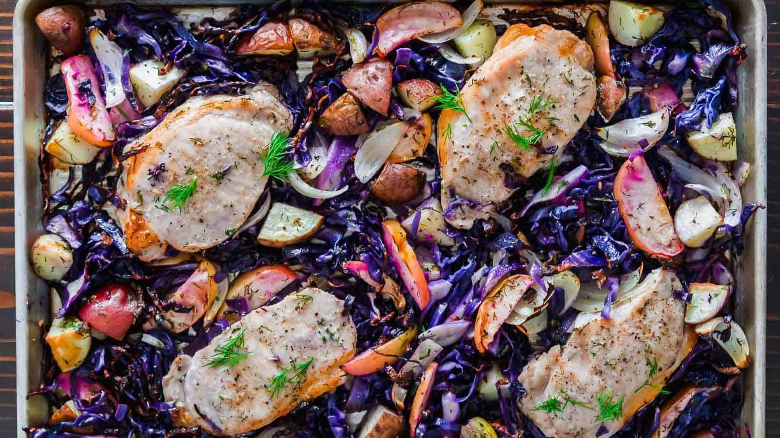 Red cabbage and chicken with potatoes in a baking pan.