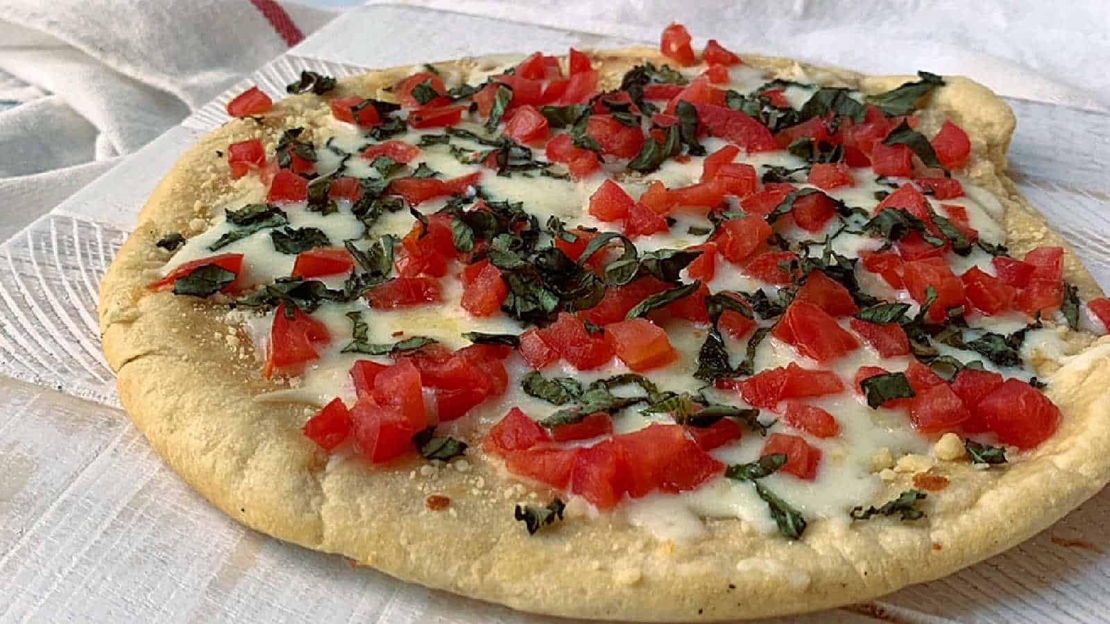 Margherita pizza on a white cutting board.