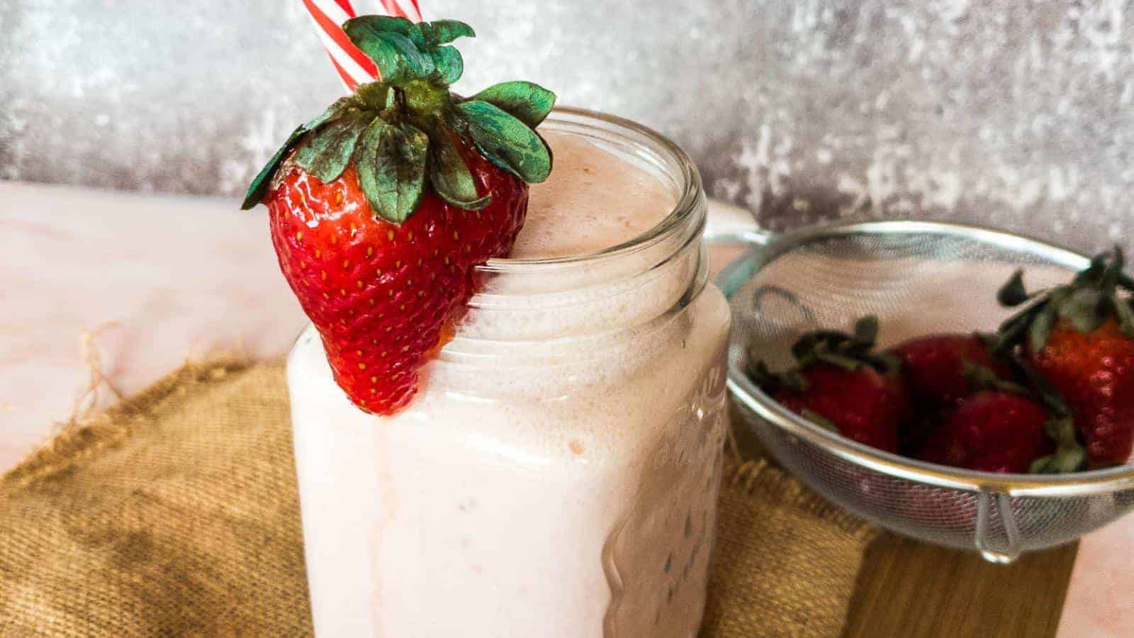 Enjoy an easy breakfast with a refreshing strawberry smoothie served in a mason jar with a straw.