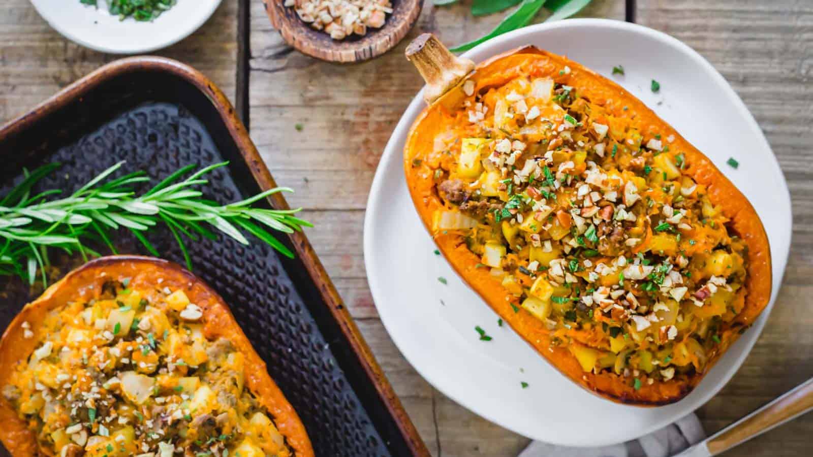 Two stuffed honeynut squash halves on a wooden table.